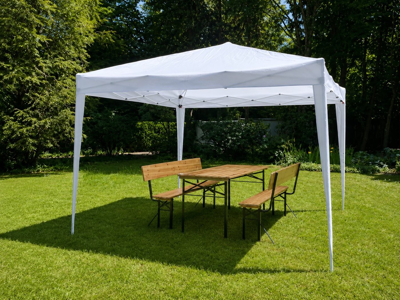 Faltpavillon mit Bierzeltgarnitur auf einer Wiese im Sonnenschein